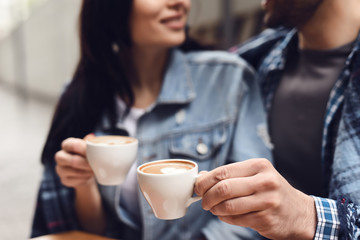 Close up. Guy with a girl is drinking coffee.