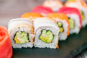 Rainbow sushi roll on tray with ginger close up