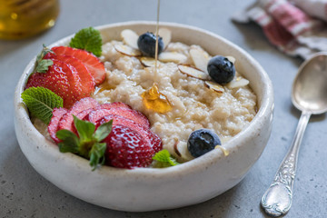 Steel cut oatmeal porridge with strawberry and blueberry for breakfast
