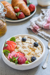 Steel cut oatmeal porridge with strawberry and blueberry for breakfast