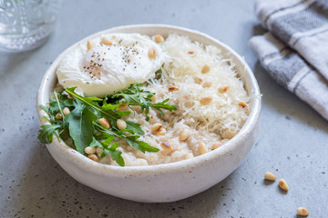 Cheese savoury oatmeal with poached egg and arugula