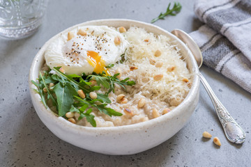 Cheese savoury oatmeal with poached egg and arugula