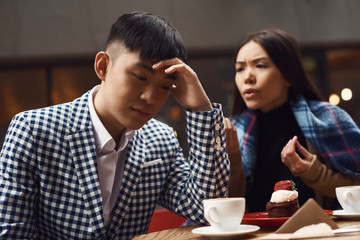 Couple screeches in coffee shop at table.