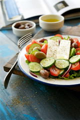 Traditional Greek salad. Light and healthy food. Blue  food background
