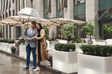 Girl with guy with umbrella.
