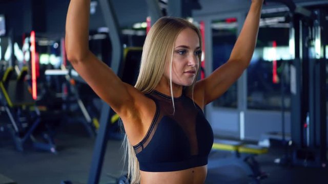 Sportive woman with dumbbells pumping up biceps