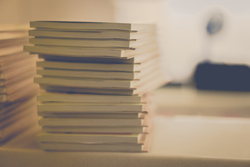 Many books stacked on a table in a library.