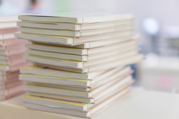 Many books stacked on a table in a library.