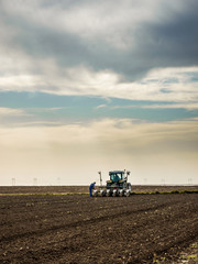 Farmer seeding, sowing crops at field. Sowing is the process of planting seeds in the ground as part of the early spring time agricultural activities.