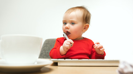 Happy child baby girl toddler sitting with keyboard of computer isolated on a white background