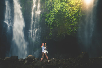 Amazing romantic view of happy couple near beautiful grand waterfall
