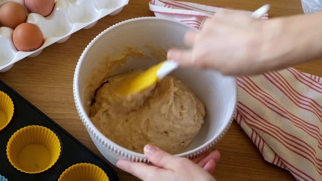 Woman mixings dought for muffins