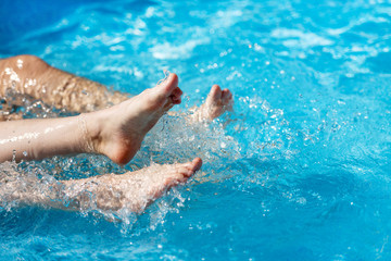  Leg female in the water in the pool, close-up.