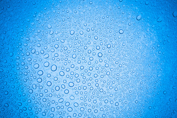 Rain droplets on blue glass background, Water drops on glass.