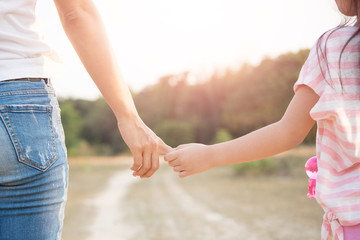 a parent holds the hand of a Children