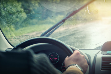 Fototapeta na wymiar Car windshield in the rain drops, wipers, view from inside the cabin.