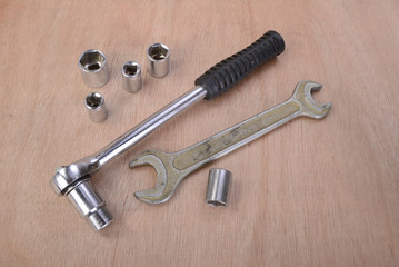 various professional metalwork tools on a background of beech wood