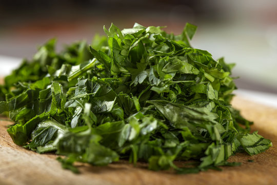 Close up of fresh green chopped parsley on wood