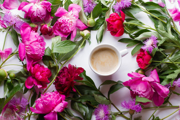 Morning coffee and beautiful pink and red peony flowers on white table top view in flat lay style. Cozy breakfast on Mother or Woman day.