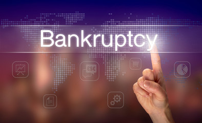 A hand selecting a Bankruptcy business concept on a clear screen with a colorful blurred background.