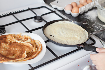 Woman fry pancakes at the traditional Russian holiday  Carnival Maslenitsa Shrovetide