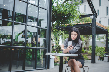 Portrait of young businesswoman use mobile phone while sitting in comfortable coffee shop during work break, charming happy female reading fashion news on cell telephone