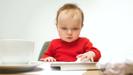 Happy child baby girl toddler sitting with keyboard of computer isolated on a white background