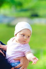 Young beautiful, adorable girl lying on a bed with white background. Parent and child are laughing and playing together. Cute baby and childhood concept. 