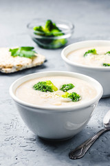 Garlic, parsnip white bean broccoli soup puree in a bowl on blue concrete background. Selective focus, space for text. 