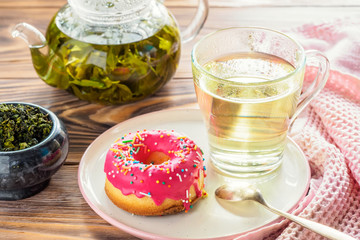 Cup of hot green tea beverages with donut glazed