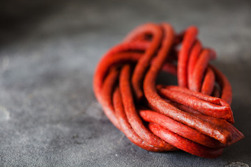 Long thin dry sausage on dark slate background