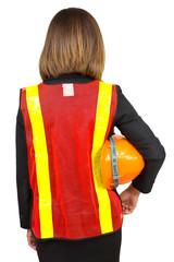 Business woman wearing orange shirt standing safely holding a helmet in an industrial safe.