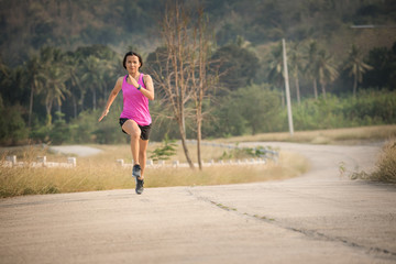 Young lady running on a rural road during sunset, sports, healthy lifestyle