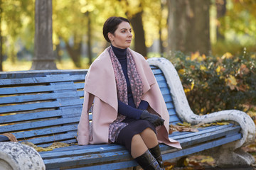 A woman dreams in an autumn park