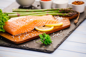 Fresh raw salmon fish served on black stone on wooden table