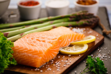 Fresh raw salmon fish served on black stone on wooden table