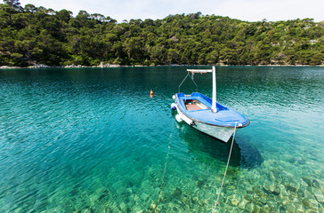 Fototapeta na wymiar Lonely boat at blue lagoon