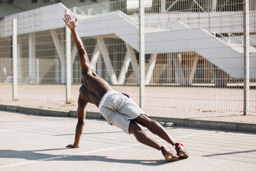 African American man stretches before starting his exercises on the street