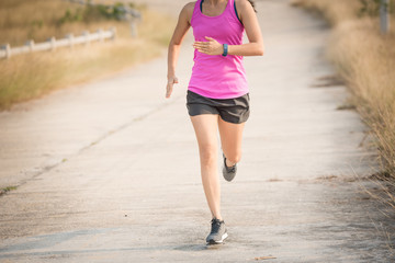 Young lady running on a rural road during sunset, sports, healthy lifestyle