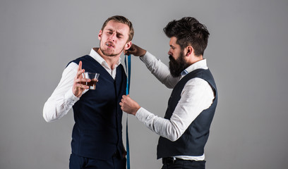 Young businessman visit tailor. Man with beard busy with measuring