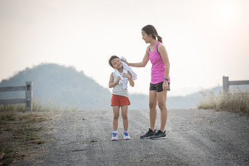 mother and her daughter running on the road in the countryside, sports, healthy lifestyle