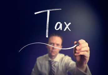 A businessman writing a Tax concept with a white pen on a clear screen.