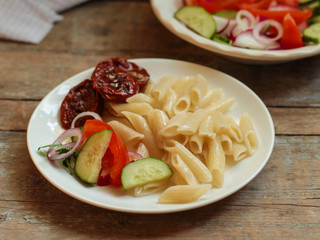 penne - a portion of pasta with dried tomatoes (meal - table setting) cuisine.  Food background