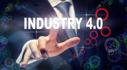 A businessman pressing a Industry 4.0 business concept on a graphical display of cogs