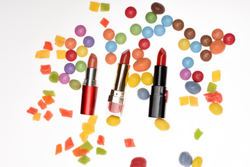 Red lipsticks, sweets, dragee, candy, candied fruit, confetti.