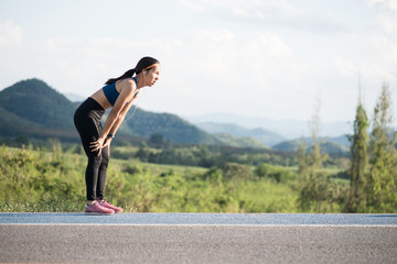 tired woman runner taking a rest after running hard