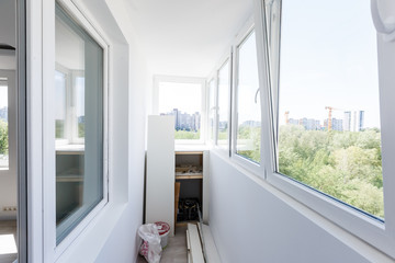 Fototapeta na wymiar White metal-plastic windows of balcony in modern apartment