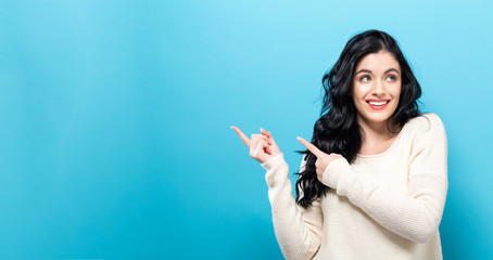 Young woman with a displaying hand gesture a solid background