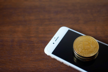 stack of Physical Bitcoins with smartphone virtual currency concept