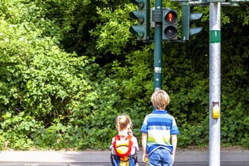 Boy and girl waiting at the red traffic light